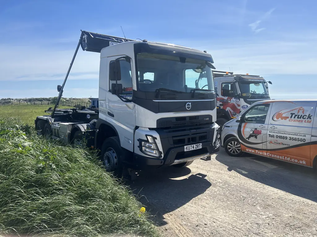 Hookloader vehicle with lifting arm visible